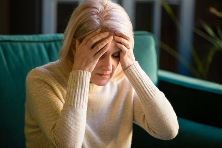 Upset stressed tired old mature woman coping with headache concept