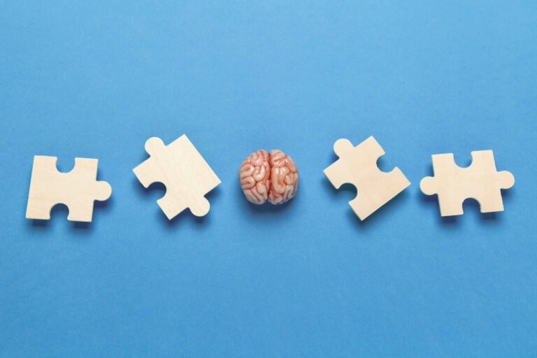 Human brain with a puzzle on blue background