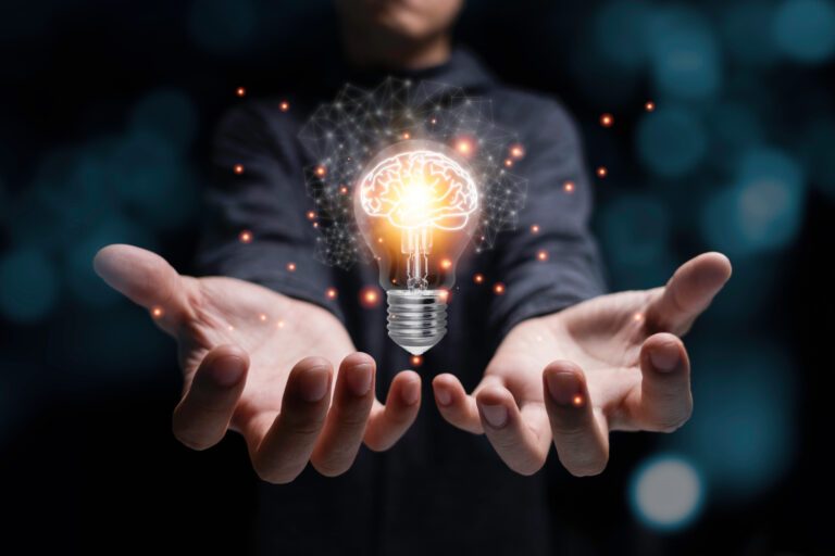 Businessman holding glowing lightbulb with virtual brain and ora